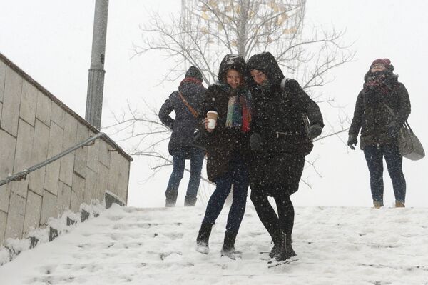 Девушки на ступеньках подземного перехода во время снегопада в Москве - Sputnik Латвия