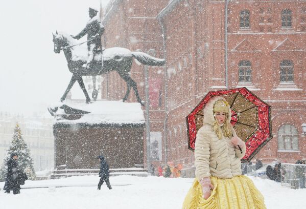Женщина с зонтом на Манежной площади во время снегопада в Москве - Sputnik Латвия