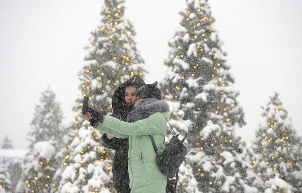 Девушки фотографируются во время снегопада на Манежной площади в Москве - Sputnik Латвия