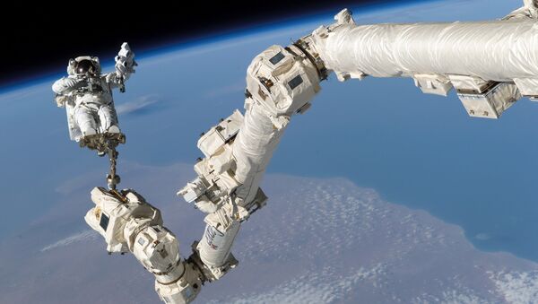 Астронавт Стивен Керн Робинсон в открытом космосе рядом с МКС - Sputnik Latvija