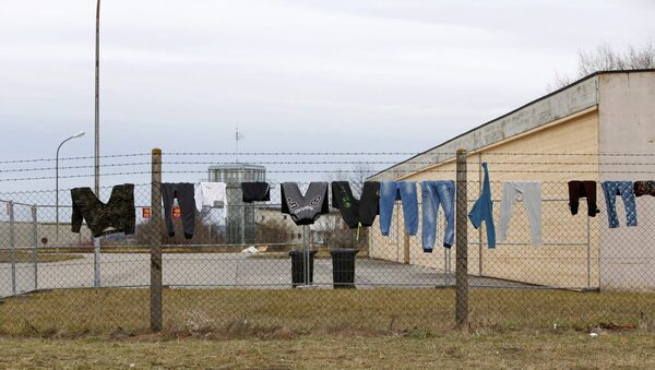 Одежда беженцев на заборе в лагере - Sputnik Latvija