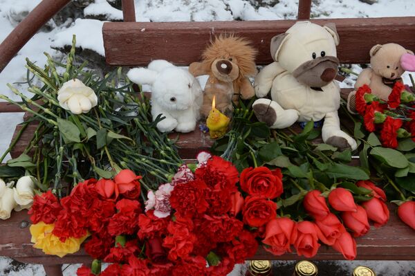 Цветы, свечи и мягкие игрушки возле здания торгового центра Зимняя вишня в Кемерове, где произошел пожар - Sputnik Латвия