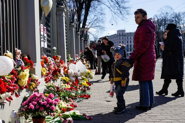 Жители Латвии третий день несут цветы и свечи к посольству России в Латвии Жители Латвии третий день несут цветы и свечи к посольству России в Латвии - Sputnik Латвия