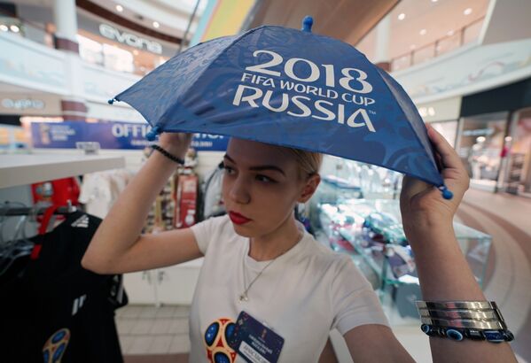 Девушка с зонтиком в официальном магазине в Калининграде по продаже сувениров и атрибутики к чемпионату мира по футболу 2018 в России - Sputnik Латвия