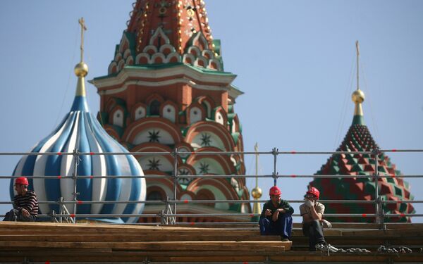 Рабочие отдыхают на строительных лесах на фоне Покровского собора на Красной площади Рабочие отдыхают на строительных лесах на фоне Покровского собора на Красной площади - Sputnik Латвия