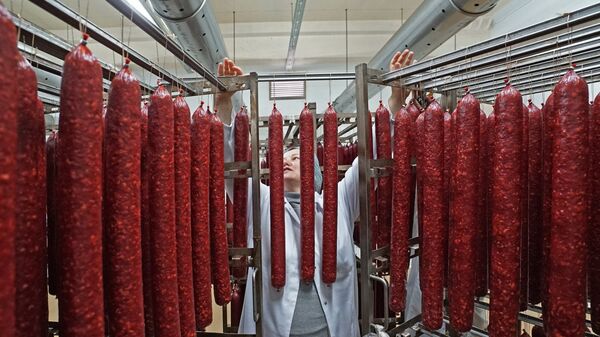 Сотрудник во время производства мясных деликатесов - Sputnik Латвия