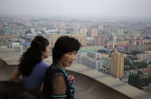 Северокорейские женщины наслаждаются пейзажем с вершины Монумента идей чучхе в Пхеньяне, Северная Корея - Sputnik Латвия