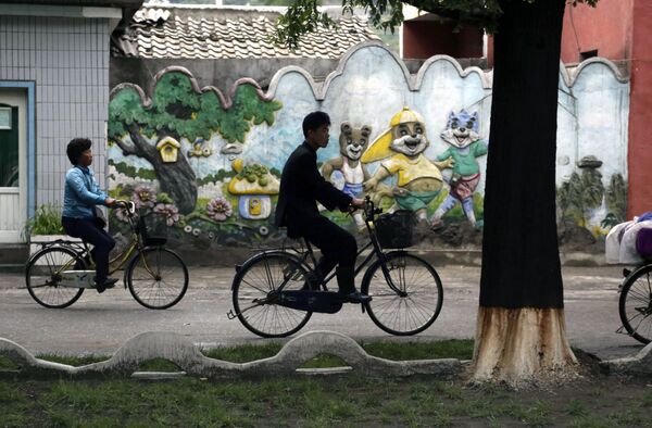 Катающиеся на велосипедах в северокорейском городе Вонсан - Sputnik Латвия
