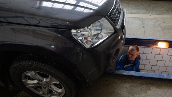 Сотрудник станции ТО СТД-Новосибирск проводит технический осмотр автомобиля. - Sputnik Латвия