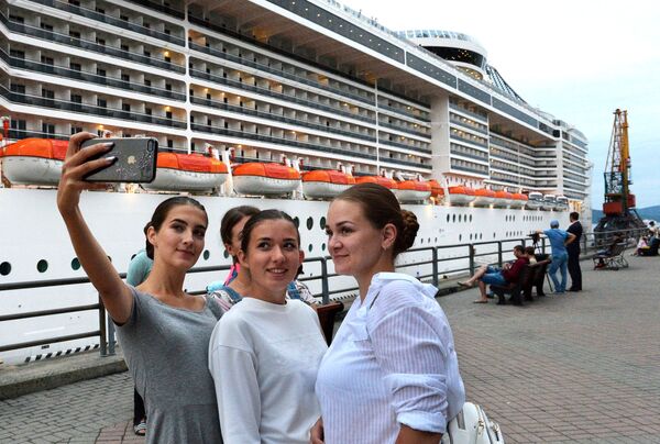 Девушки фотографируются на фоне круизного суперлайнера MSC Splendida у пирса морского вокзала во Владивостоке Девушки фотографируются на фоне круизного суперлайнера MSC Splendida у пирса морского вокзала во Владивостоке - Sputnik Латвия