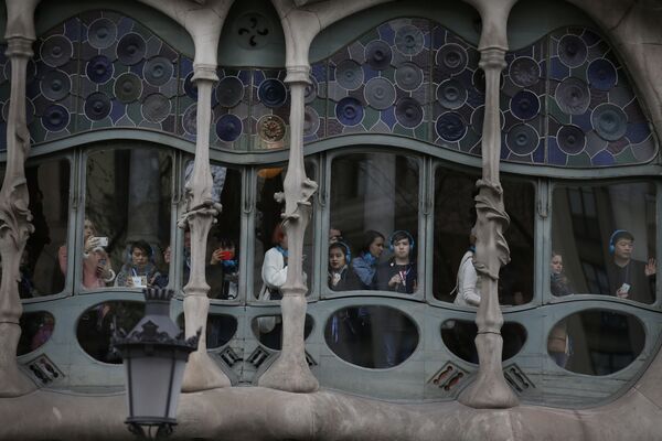 Tūristi skatās pa logu no arhitekta Antonio Gaudi Casa Batllo ēkas Barselonā, Spānijā - Sputnik Latvija