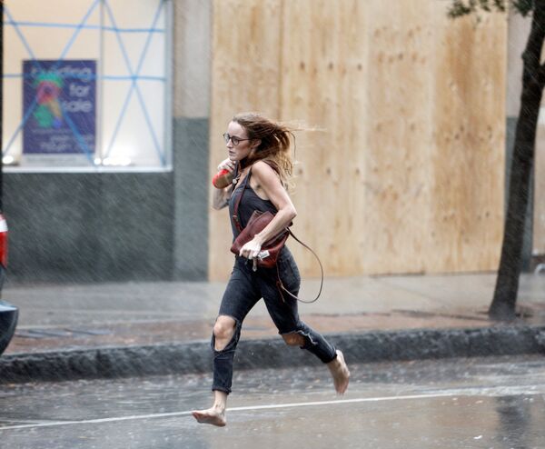 Девушка бежит босиком во время урагана Флоренс в Уилмингтоне, США - Sputnik Латвия