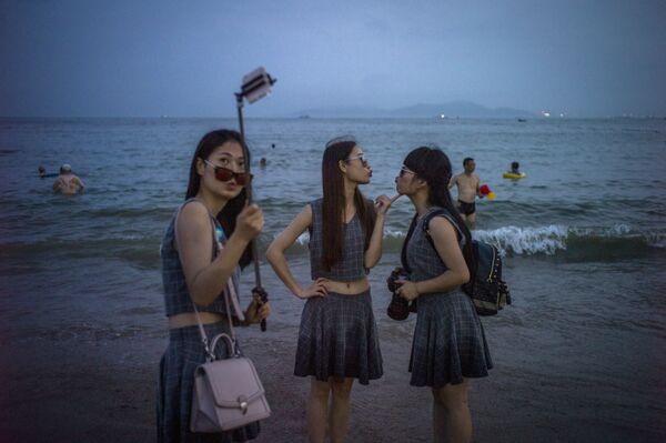 Китаянки фотографируются на пляже города Циндао - Sputnik Латвия