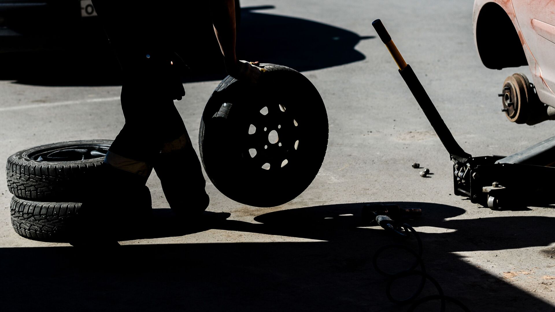 Работник меняет колесо в шиномонтажной мастерской - Sputnik Латвия, 1920, 22.10.2023