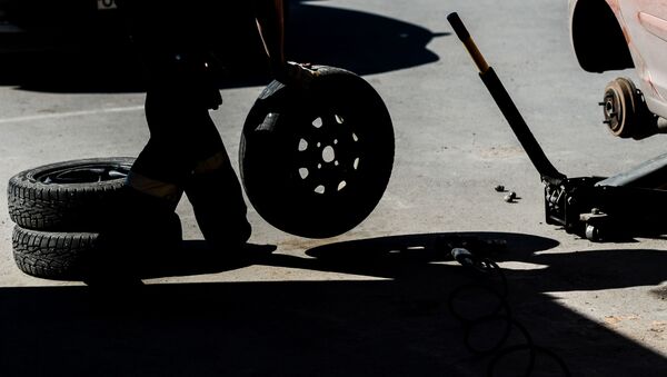 Работник меняет колесо в шиномонтажной мастерской - Sputnik Latvija